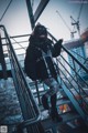 A woman wearing a face mask standing on a set of stairs.